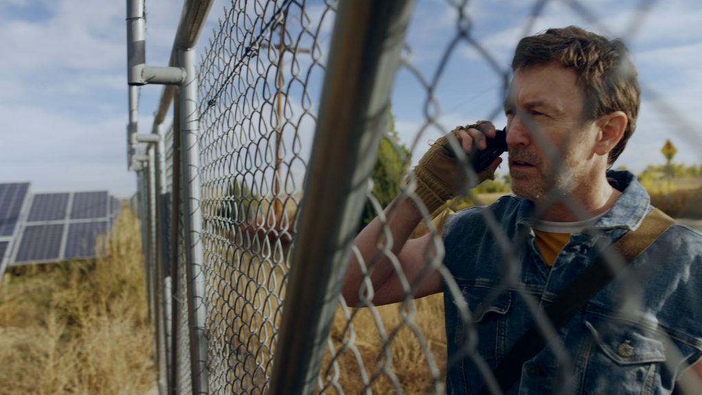 Satire Brewing Company film still looking through fence